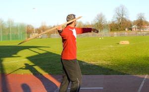 A javelin athlete throwing a replica Neanderthal spear