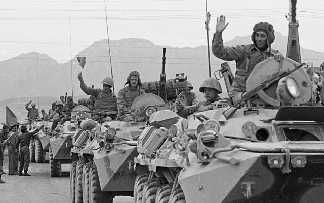 A convoy of Soviet troops waves to crowds during its withdrawal from Afghanistan on May 15, 1988.