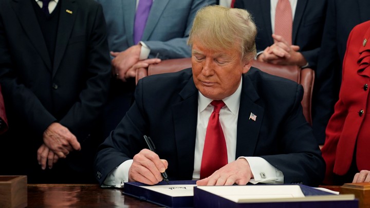 Donald Trump signs the First Step Act and the Juvenile Justice Reform Act in the Oval Office on December 21, 2018.