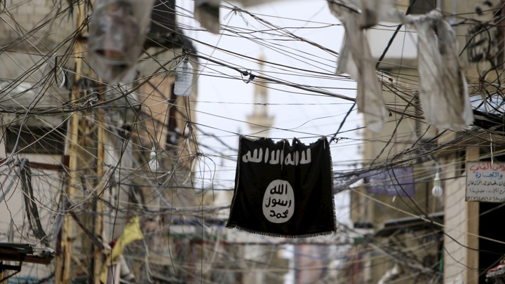An Islamic State flag hangs amid electrical wires over a street in Lebanon.