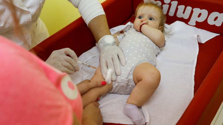 A baby receives a vaccine injection.