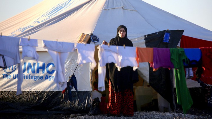 A woman hangs laundry at a refugee camp in Syria in March 2017.