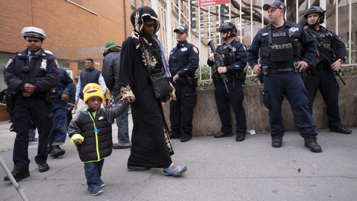 People leave the Islamic Cultural Center of New York under increased police security following the shooting in New Zealand.