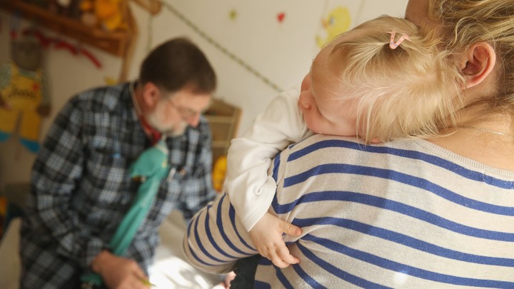 A woman holds a small child.