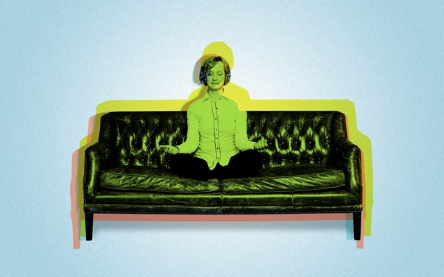 A woman meditating on a couch