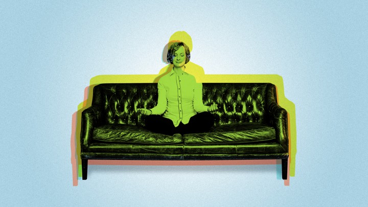 A woman meditating on a couch