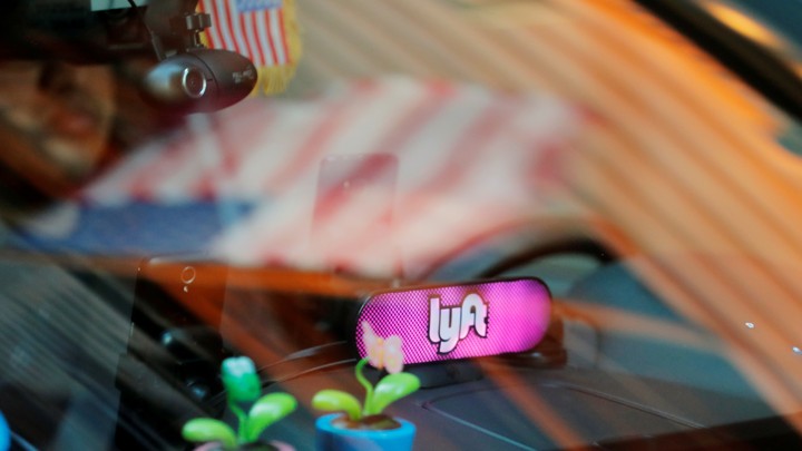A car with a Lyft logo in its window