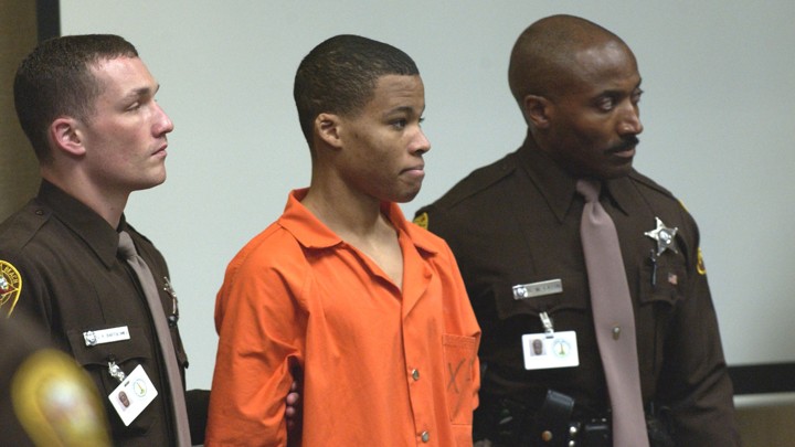 Lee Malvo is surrounded by deputies as he is brought into court.