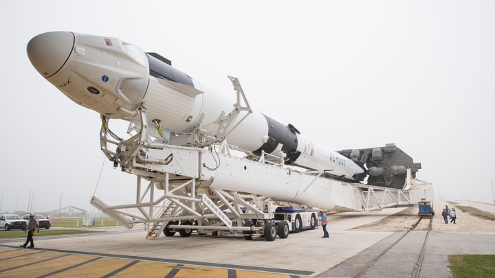 A SpaceX Falcon 9 rocket, with the company's Crew Dragon spacecraft onboard, on its way to the launchpad