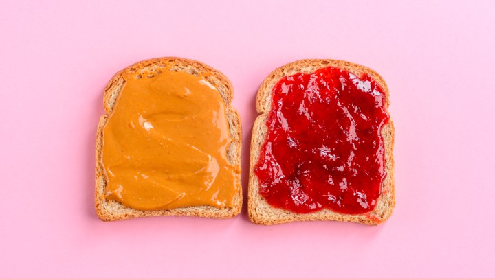 Two pieces of bread—one spread with peanut butter and one spread with jelly