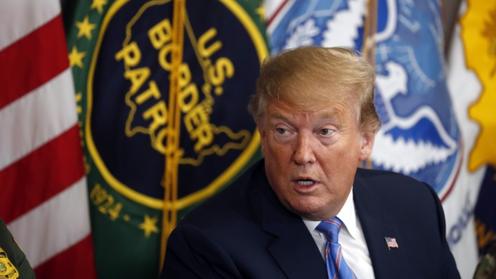 President Donald Trump in front of a U.S. Border Patrol flag