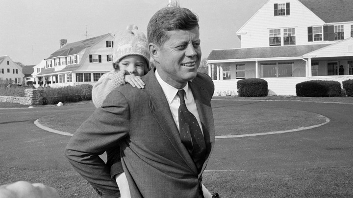John F. Kennedy with his daughter on his back