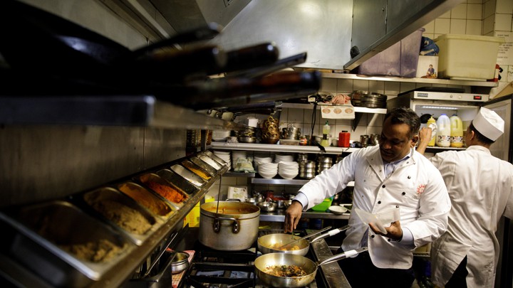 The owner of a London "curry house" cooks a meal.