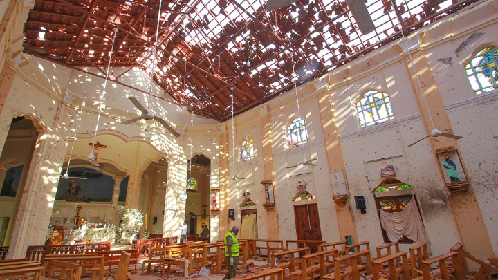 A crime-scene official inspects the site of a bomb blast inside a church in Negombo, Sri Lanka.