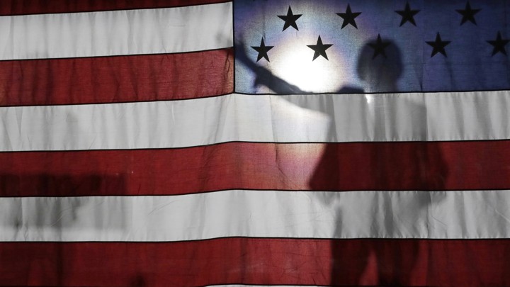 Senator Elizabeth Warren is seen in silhouette giving a speech to a crowd in Queens, New York.