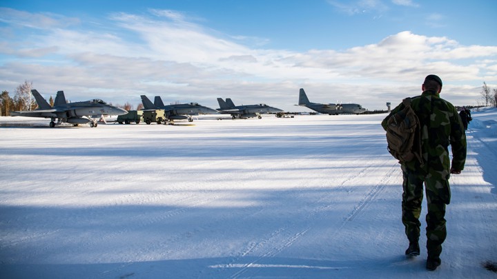 A soldier approaches planes on an icy field.
