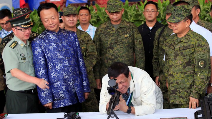 Philippine president Rodrigo Duterte checks the scope of a rifle at a ceremony marking the turnover of free Chinese military assistance to the Philippines at Clark Air Base in June 2017.