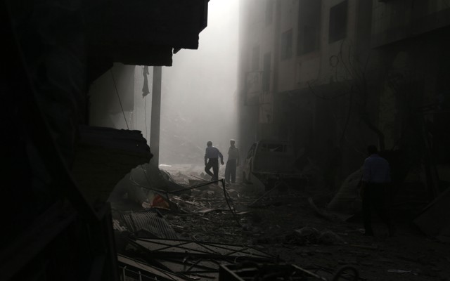 Residents inspect damage from what activists said was an air strike by forces loyal to Syrian President Bashar al-Assad on the town of Douma in Damascus, Syria, on October 2, 2015.