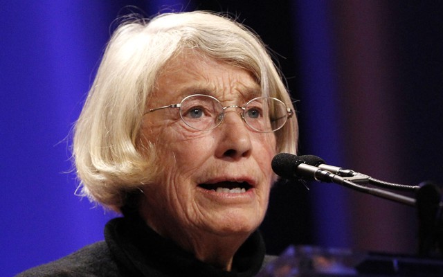 The poet Mary Oliver speaks at a podium.