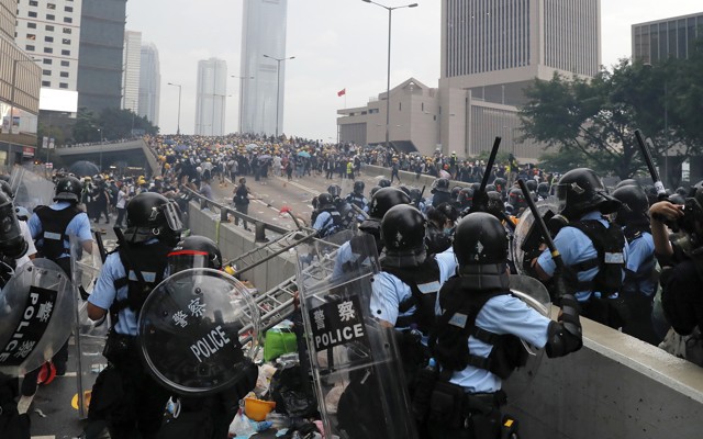 Riot police prepare to throw tear gas at protesters in Hong Kong.