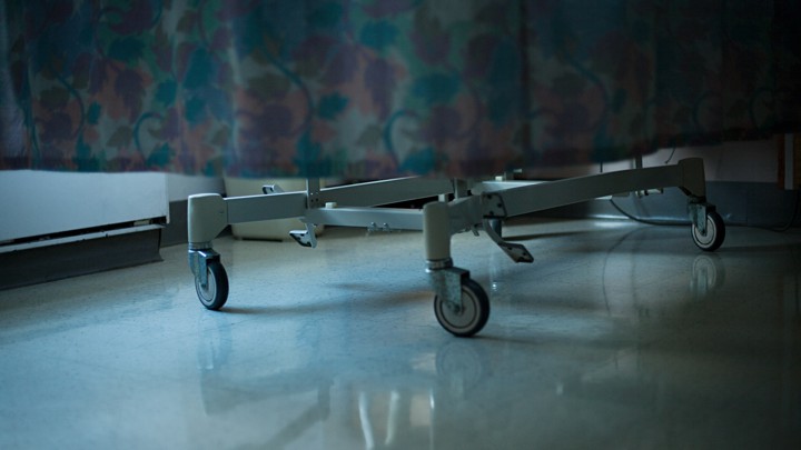 The bottom of a hospital bed is pictured being wheeled through a hospital.