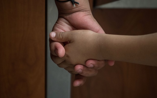 A Honduran asylum seeker, recently released from federal detention with fellow immigrants, holds the hand of her 6-year-old daughter at a bus depot in McAllen, Texas, on June 11, 2019.