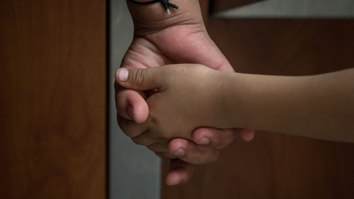 A Honduran asylum seeker, recently released from federal detention with fellow immigrants, holds the hand of her 6-year-old daughter at a bus depot in McAllen, Texas, on June 11, 2019.