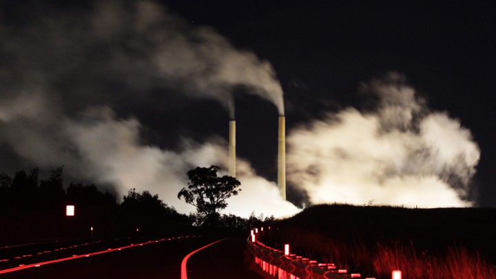 Smokestacks releasing plumes at night