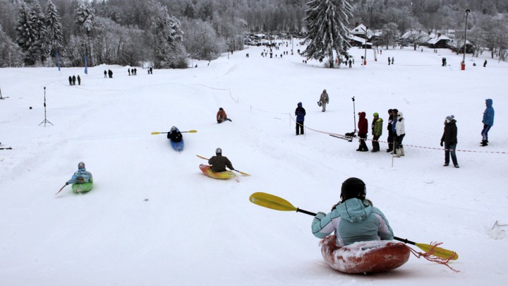 People compete during a snow-kayak downhill race near Otepää, Estonia, in 2013.