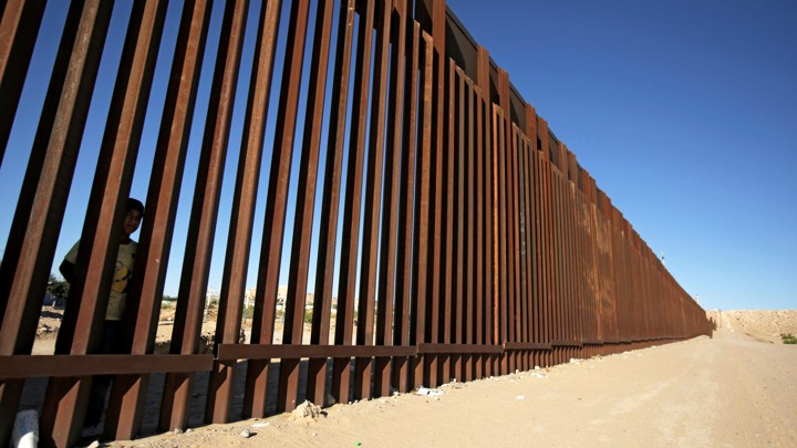 A child looks through the bars of a wall from the side of Ciudad Juarez, Mexico, in this picture taken from the side of El Paso, Texas.