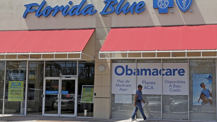 A person walks by a health-care insurance office in Hialeah, Florida.