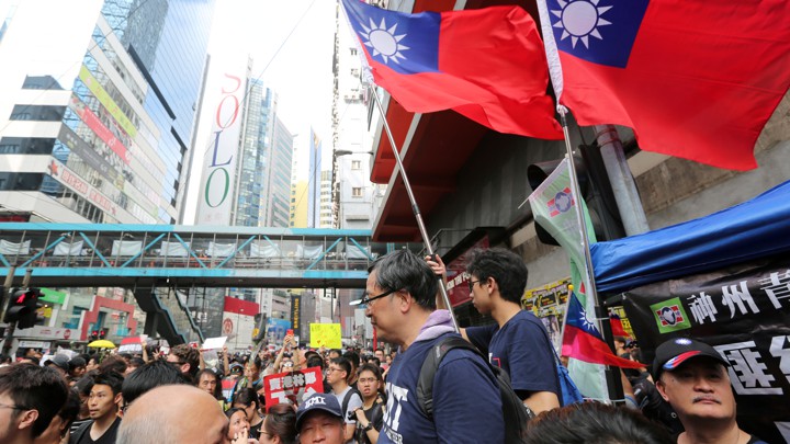 Protesters wave Taiwanese flags at a rally in Hong Kong.