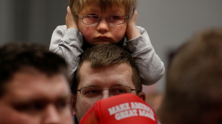 Child covers his ears during a Trump campaign rally