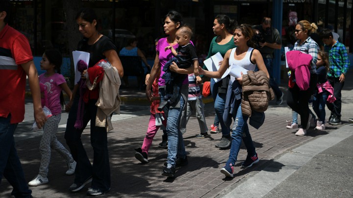 Migrant families walk to a humanitarian center after being released from federal detention in Texas.