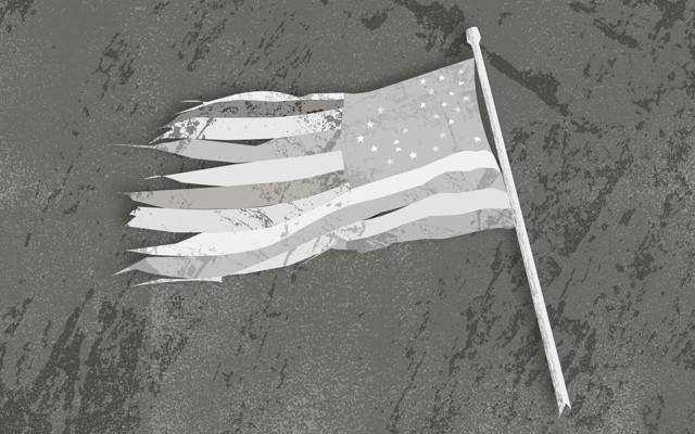 A tattered black-and-white American flag lying on the ground