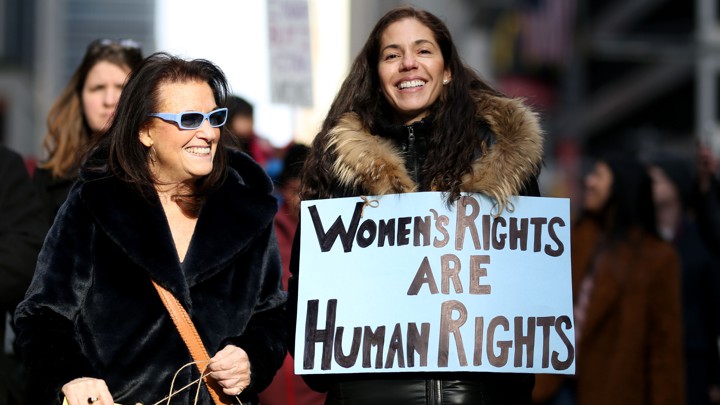 Two women hold placards in a women's rights march in New York City.