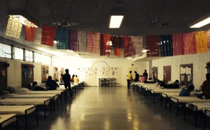 Children's bunk room with colorful flags and approximately 15 children