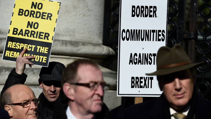 Four protestors hold signs reading, "No Border No Barrier, Respect the Remain Vote" and "Border Communities Against Brexit."