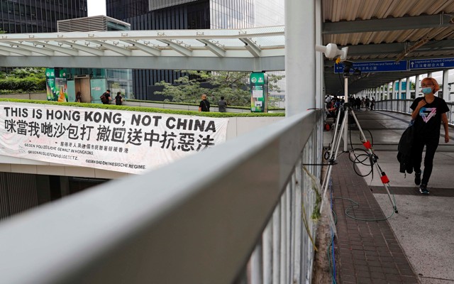 A protester walks past a banner that reads, "This is Hong Kong, not China."