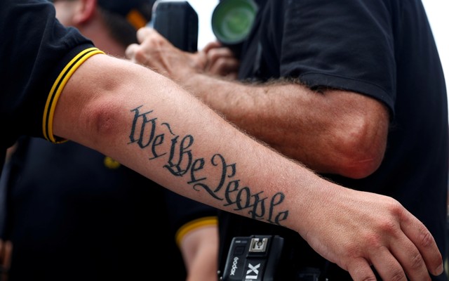 A person's arm has a tattoo that says "We The People"