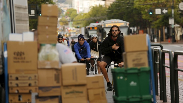 A bike lane is blocked by packages being unloaded.