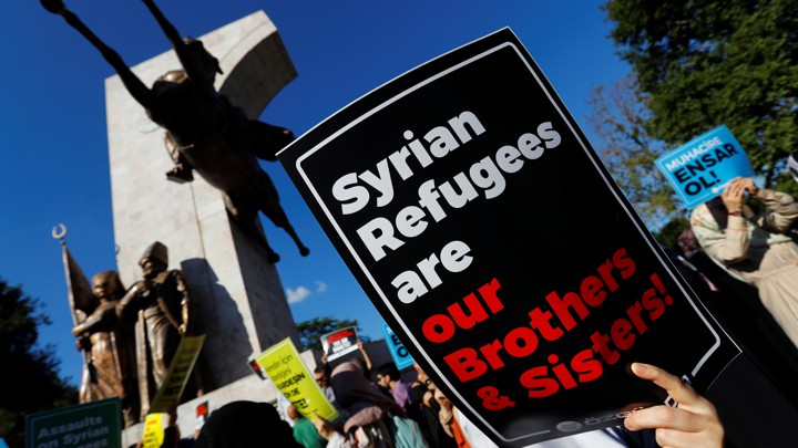 Demonstrators hold placards in support of Syrian refugees during a protest in Istanbul.