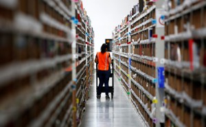 Employee looks for items in an Amazon warehouse