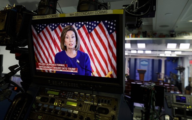 Nancy Pelosi appears on a video screen at the back of the White House press briefing room.