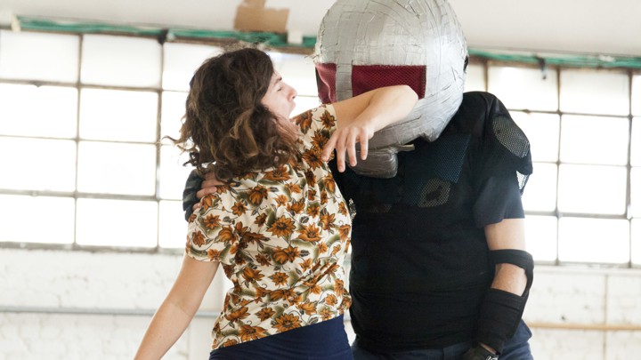 A woman elbows away an assailant in a self-defense class.