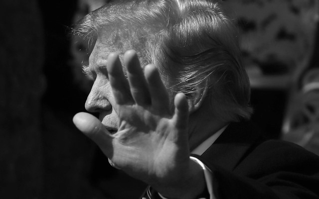 Donald Trump putting a hand in front of his face