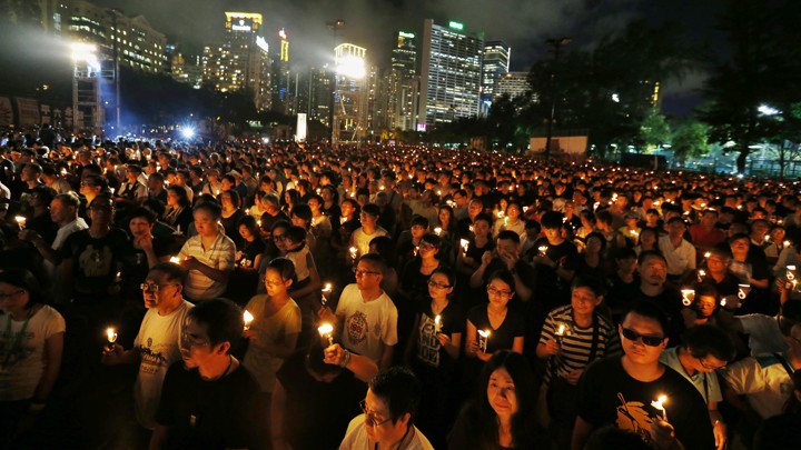 A large crowd of Hong Kong residents participates in a candlelight vigil in Victoria Park, Hong Kong.