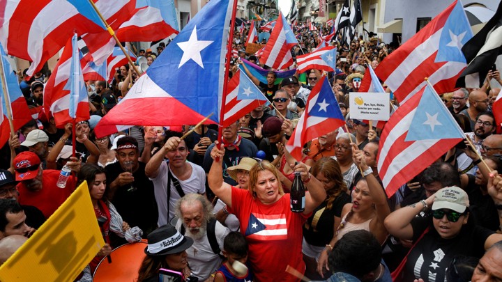 A crowd waving Puerto Rican flags