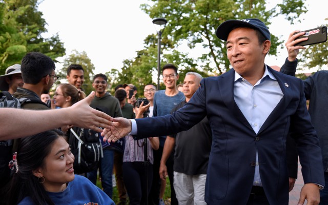 Andrew Yang shakes hands with supporters at a campaign rally.