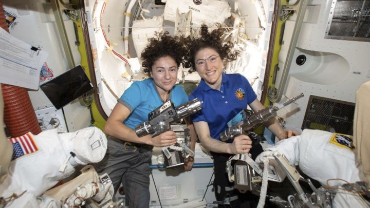 The astronauts Jessica Meir and Christina Koch pose with space drills before suiting up for their spacewalk.